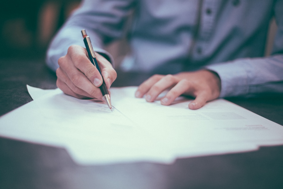 Close-up of estate planning documents and a fountain pen on a polished desk.